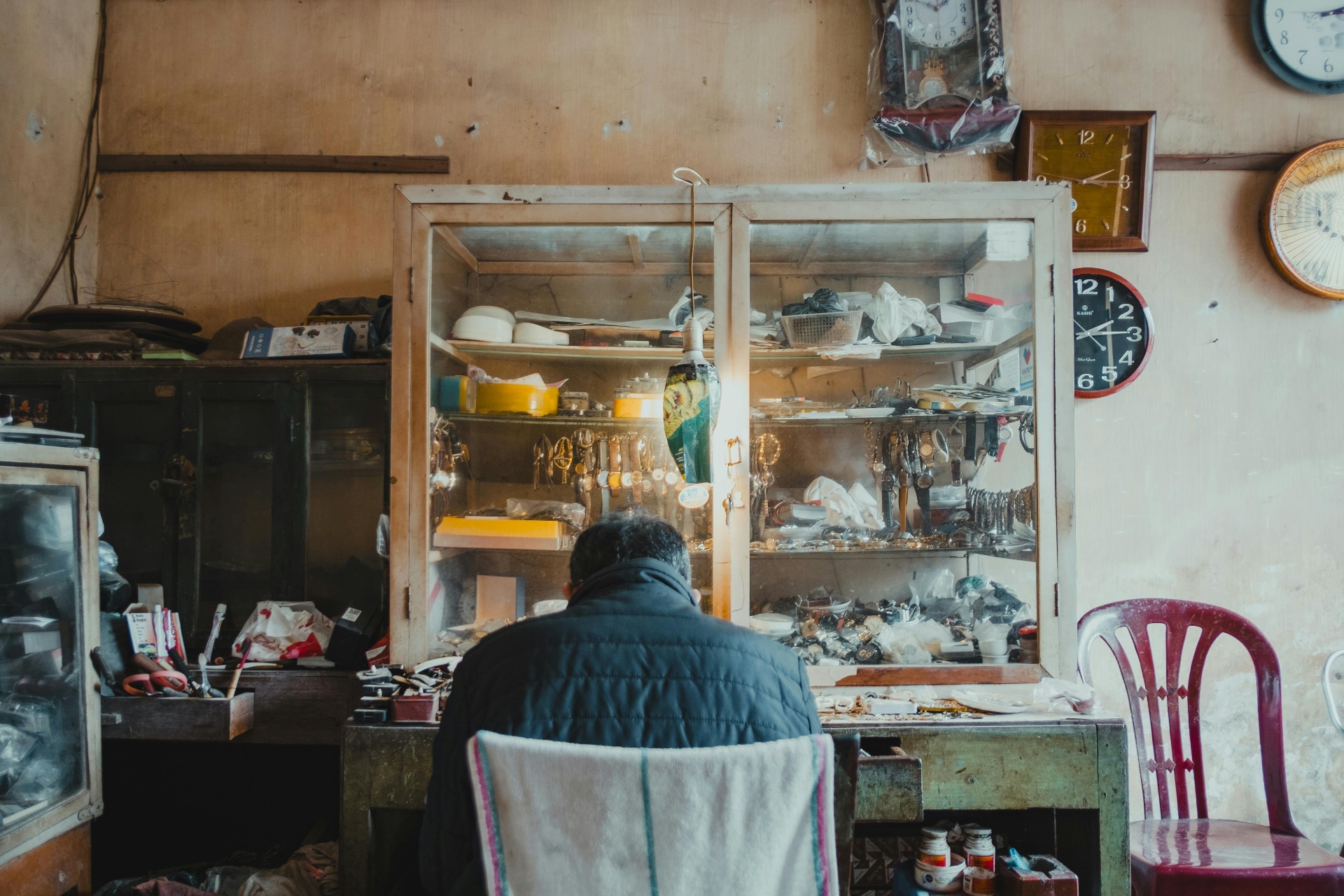 Traditional watchmaker's workshop with vintage display cases — a counterpoint to mass-market Alibaba Royal POP strap production.